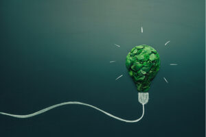 Energy saving cartoon light bulb made with green leaves.