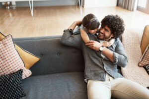 Father and daughter hugging on the couch.