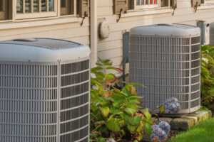 Two air conditioning units sitting outside a home.
