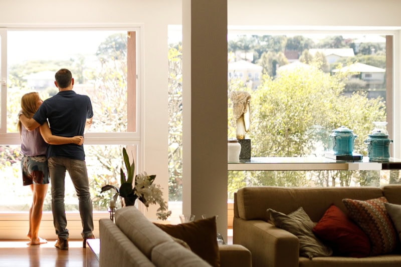 Couple standing in their living room.