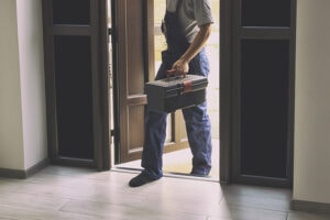 HVAC technician walking into a home to perform service.